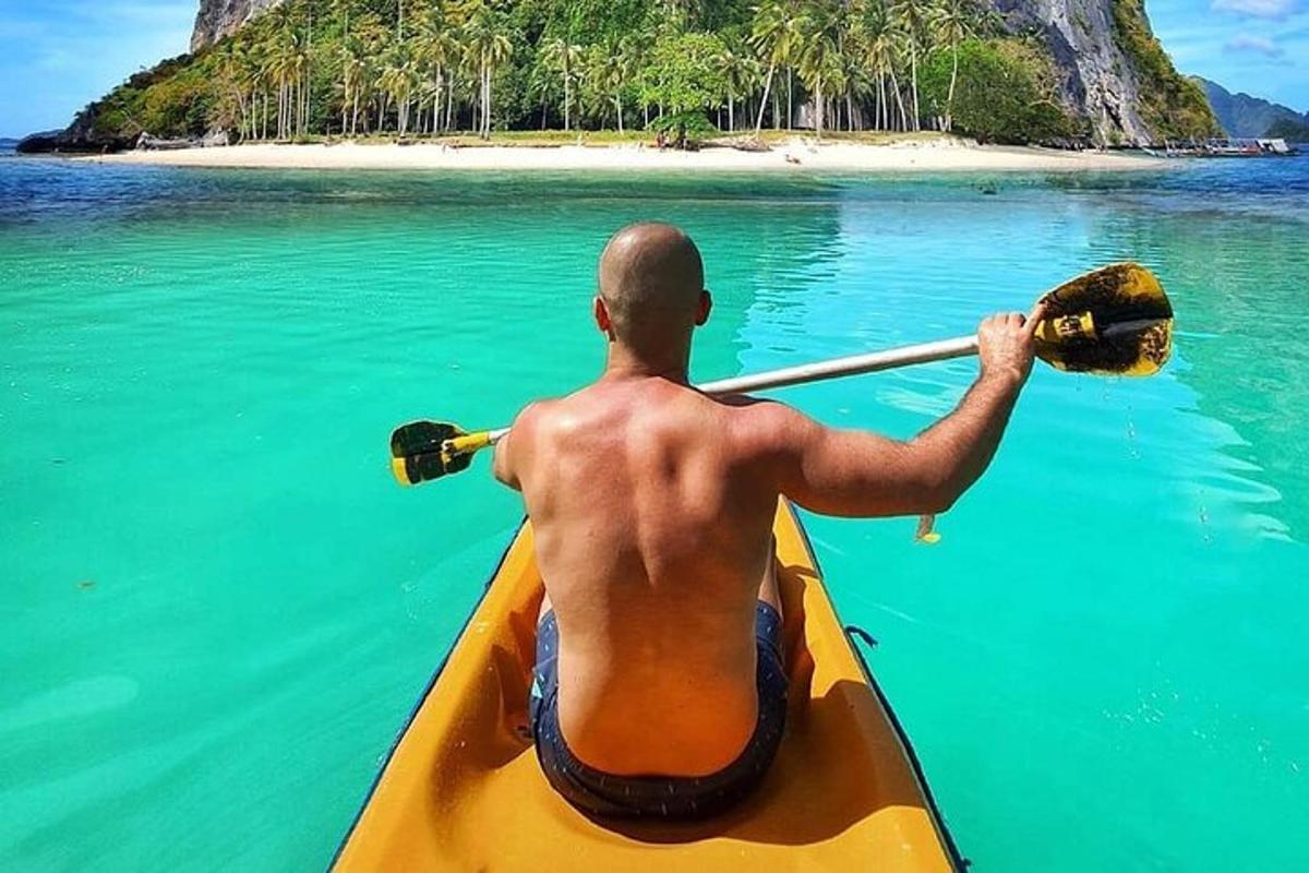 a man in a kayak in the water with an island