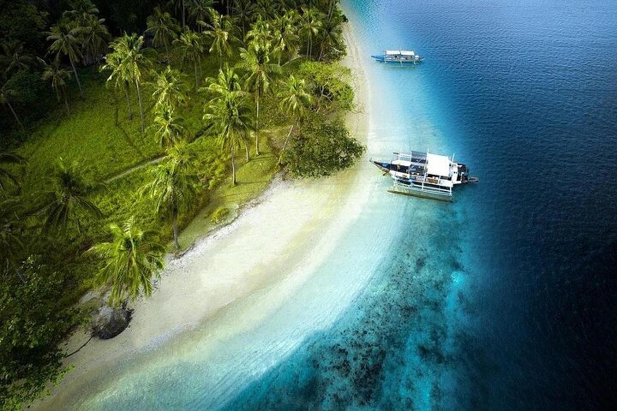 an island with a boat in the water next to a beach