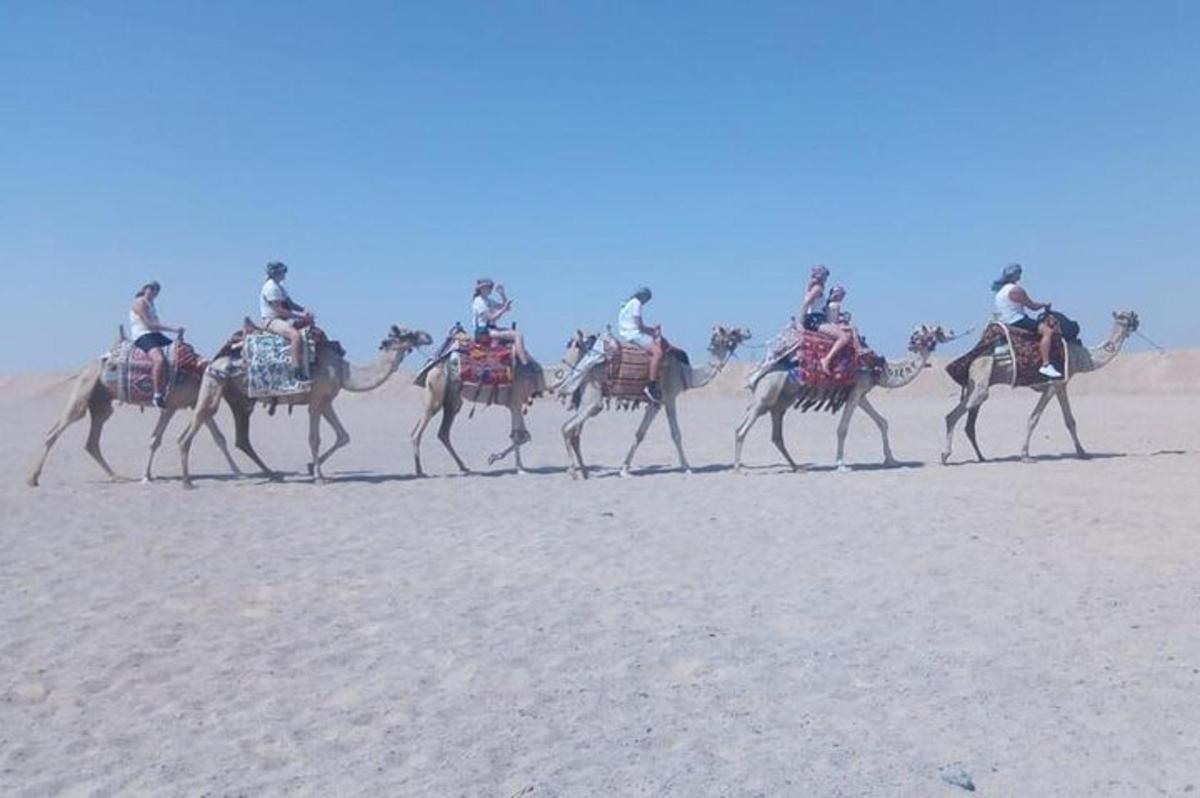 Un grupo de personas montando camellos en el desierto.