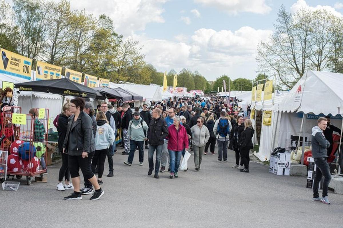 a large crowd of people walking through a market