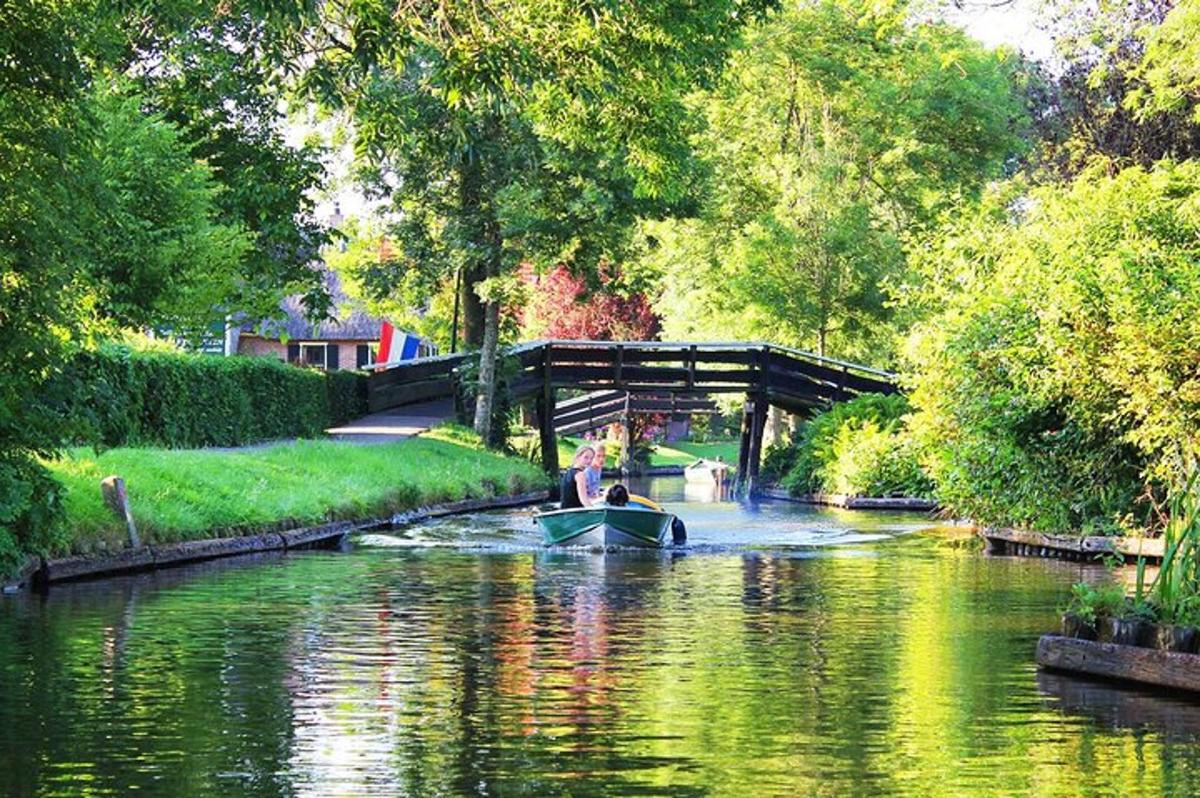 a boat traveling down a river with a bridge