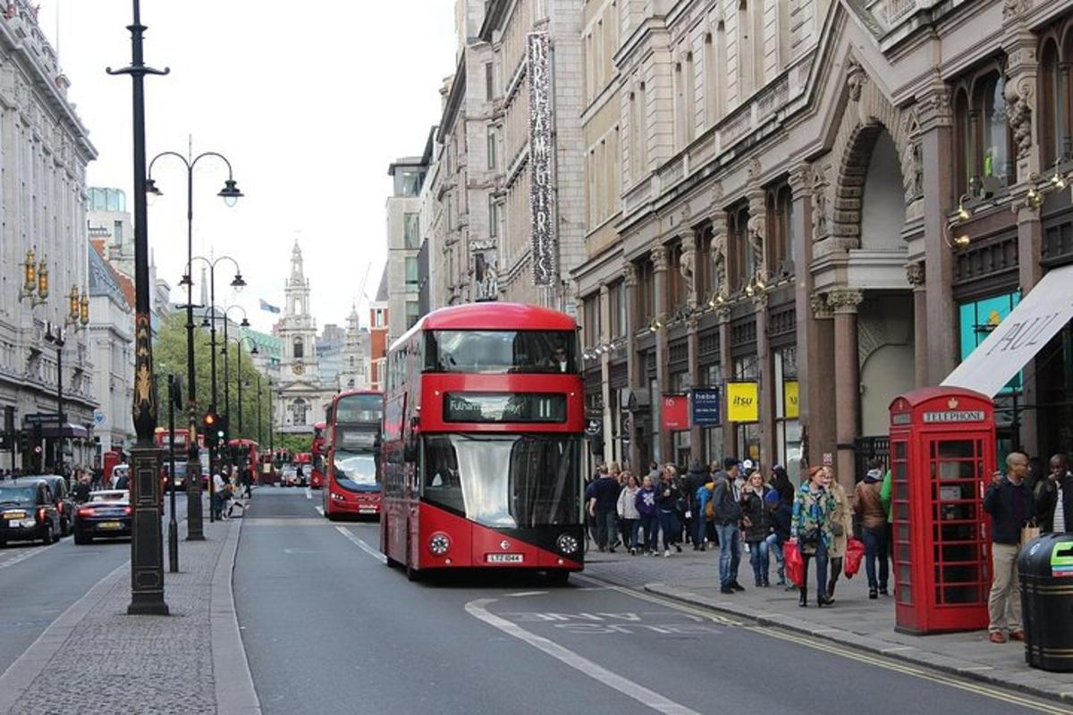 rdeč dvonadstropni avtobus, ki se vozi po mestni ulici