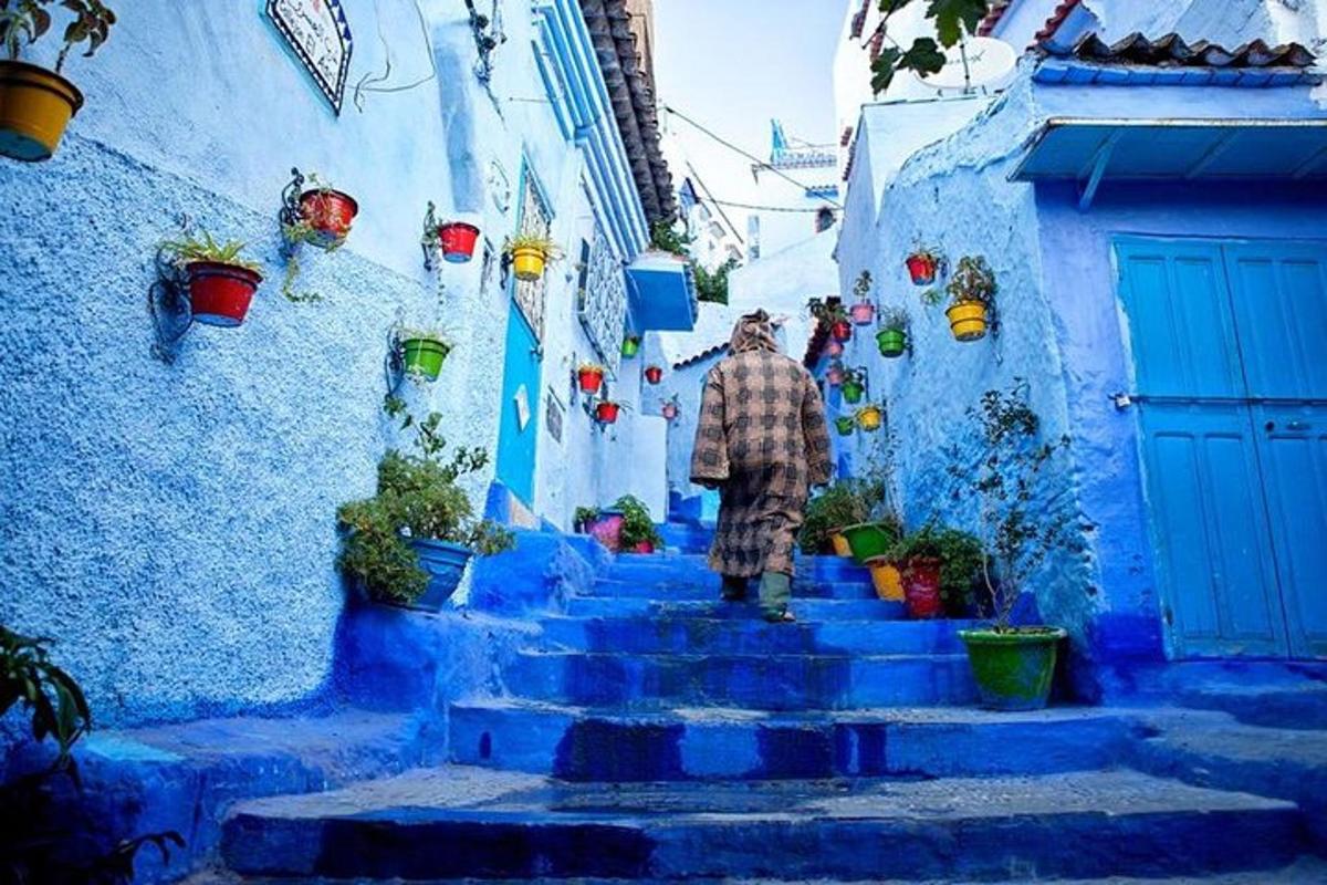 Un hombre bajando unas escaleras azules en un callejón azul.