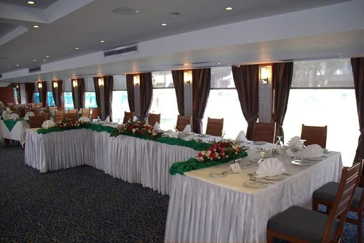 a banquet hall with white tables with flowers on it