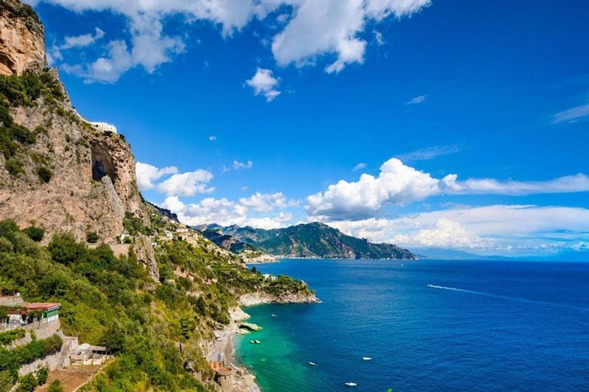 o vedere a oceanului de pe o stâncă cu un munte