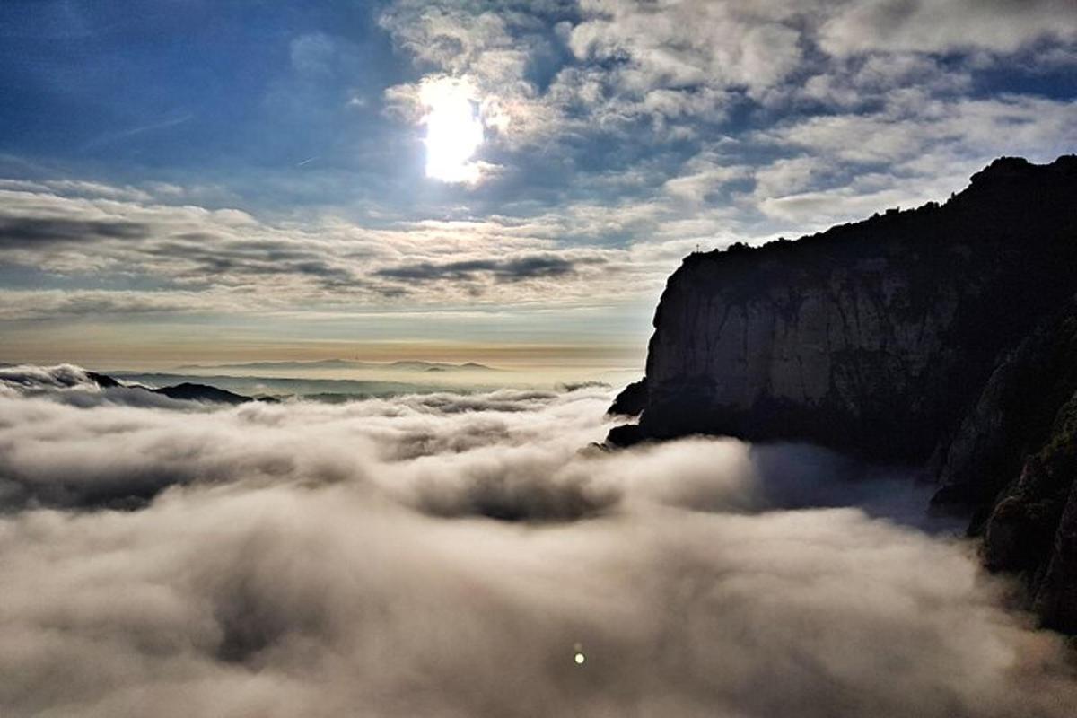 Una vista de una montaña sobre un mar de nubes.