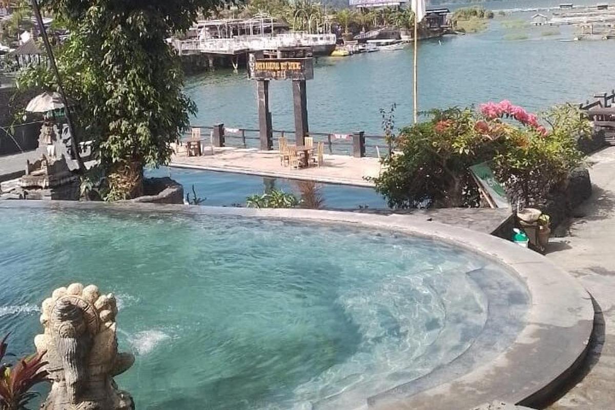 a swimming pool with a statue in front of a river