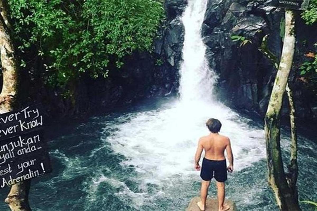 a man standing in front of a waterfall