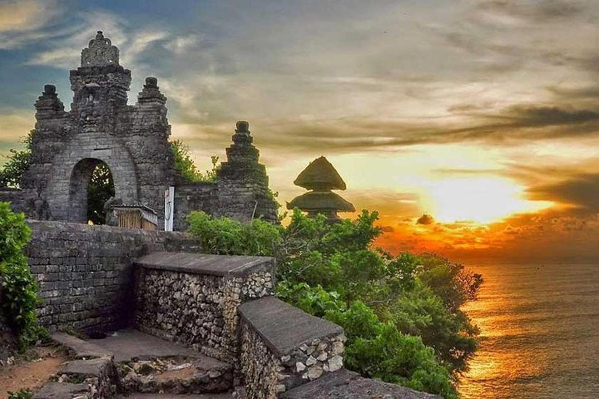 lukisan bangunan batu dengan matahari terbenam