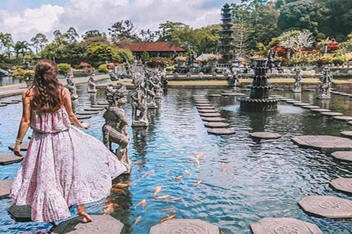 ein Mädchen in einem Kleid geht vor einem Brunnen