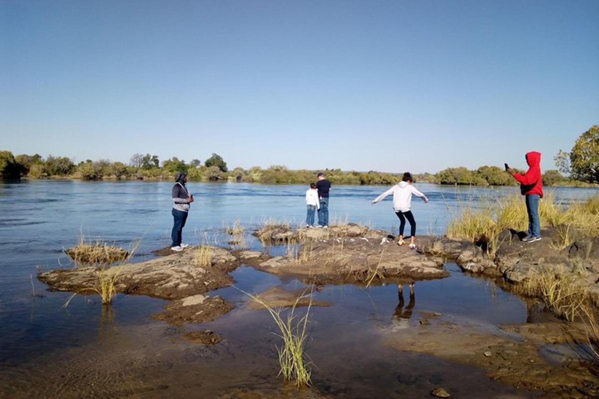 a group of people standing on rocks in the water