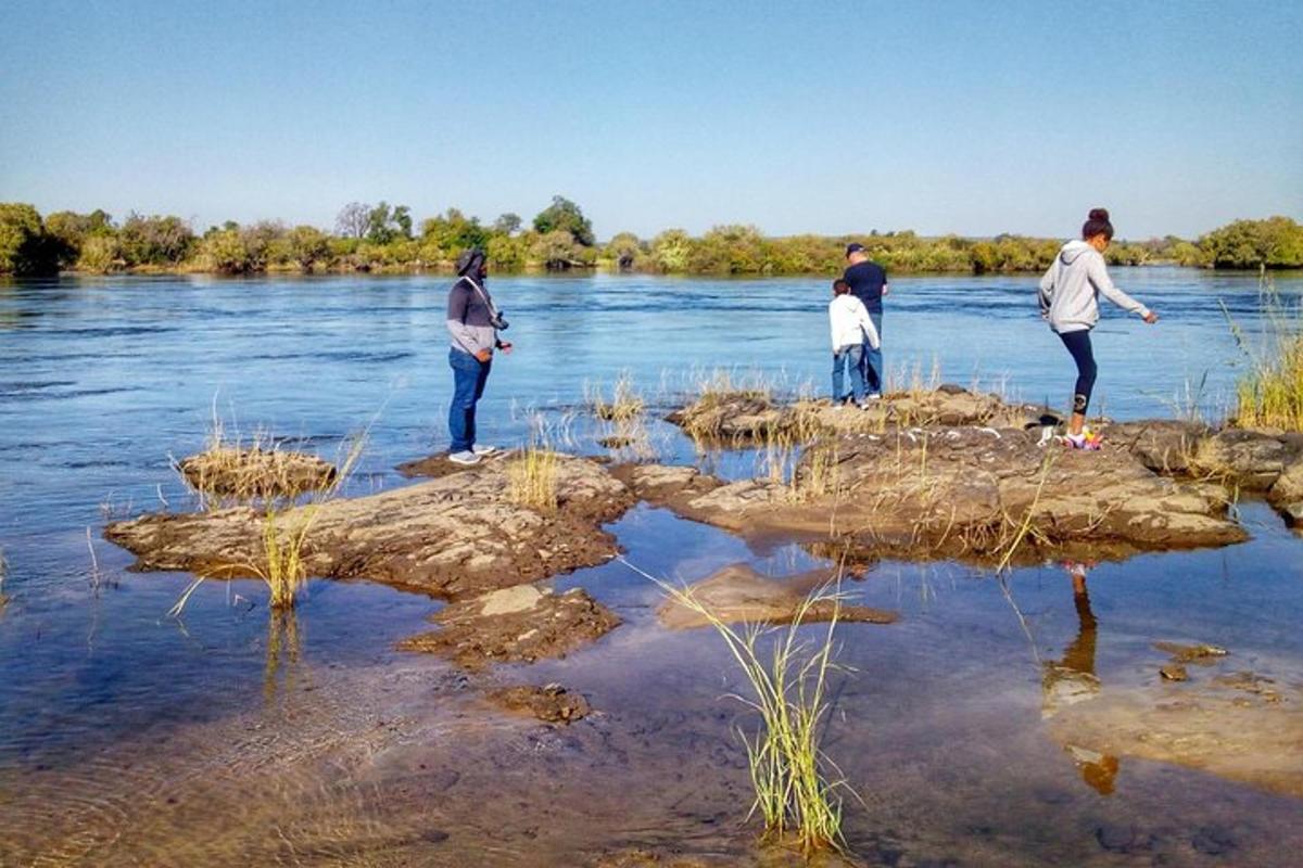 a group of people standing on rocks in the water