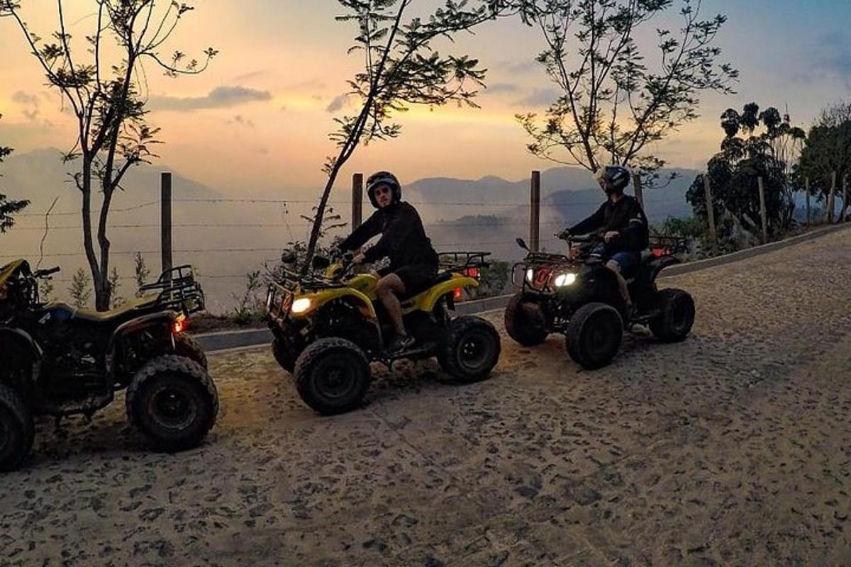 two people riding atvs on a dirt road with