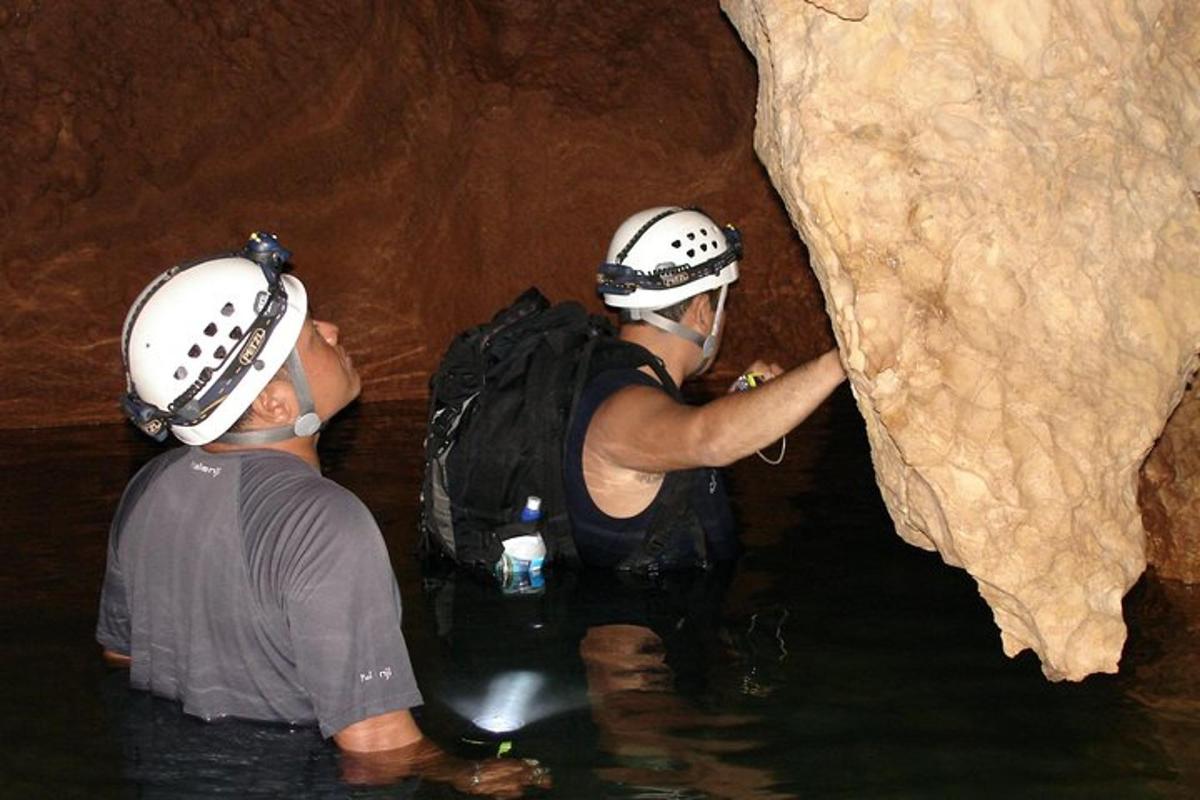 dues persones a l'aigua en una cova