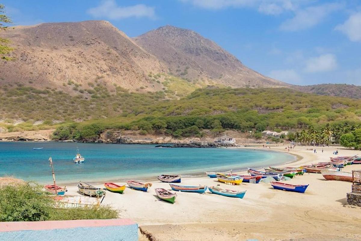 a group of boats on a beach with mountains