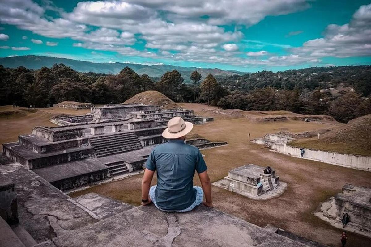a man sitting on top of a building looking out at the valley