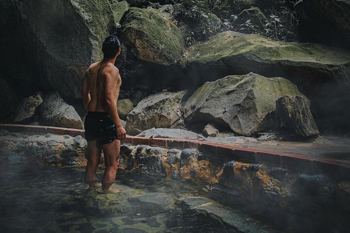 a man standing in the water in a cave