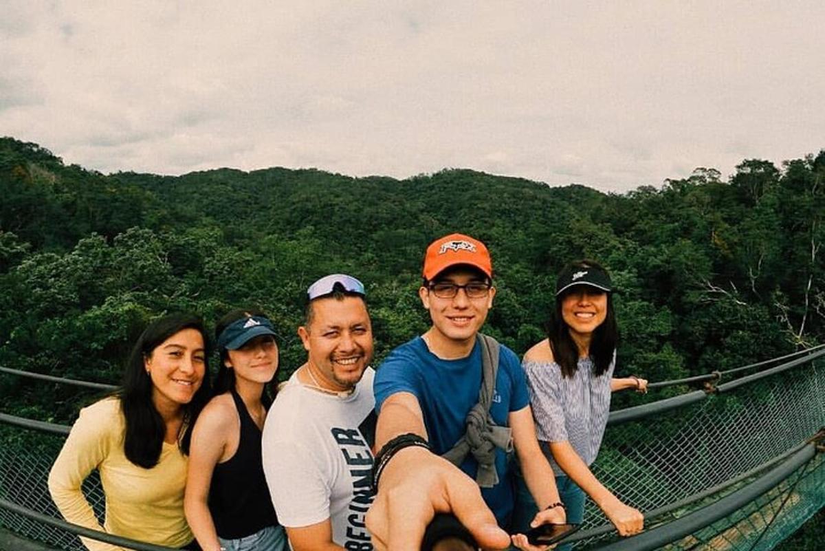 a group of people posing for a picture on a suspension bridge