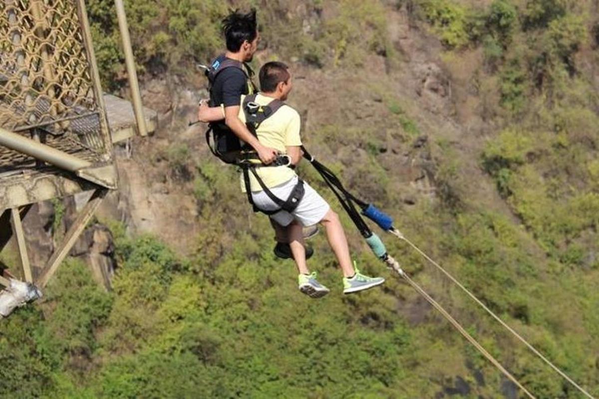two men on a zip line on a mountain