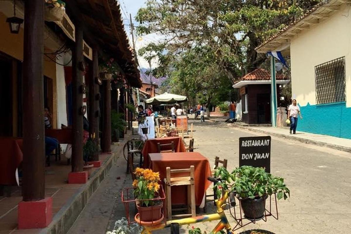 a street with tables and chairs and a sign on the street