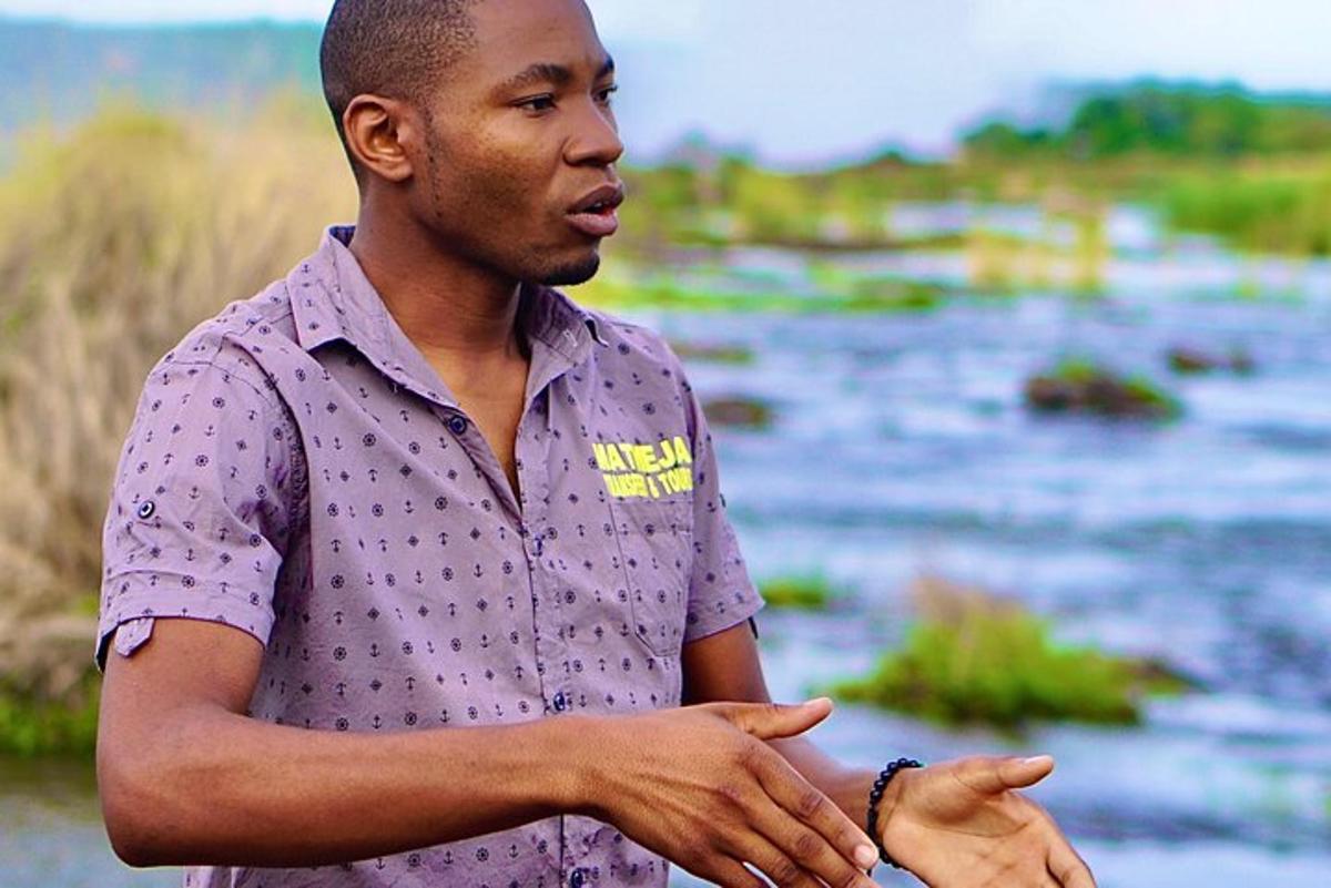 a man standing next to a body of water