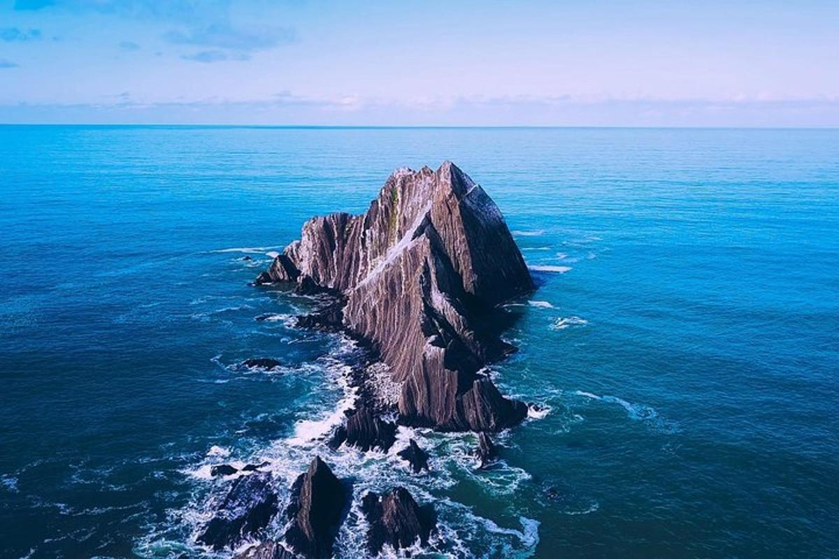 a large rock in the middle of the ocean