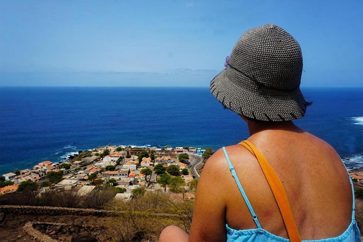 a person wearing a hat looking out at a city