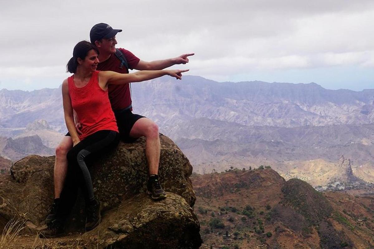 a man and a woman sitting on top of a mountain