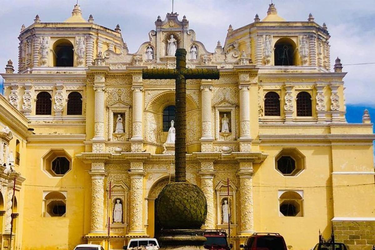 a large yellow building with a cross in front of it
