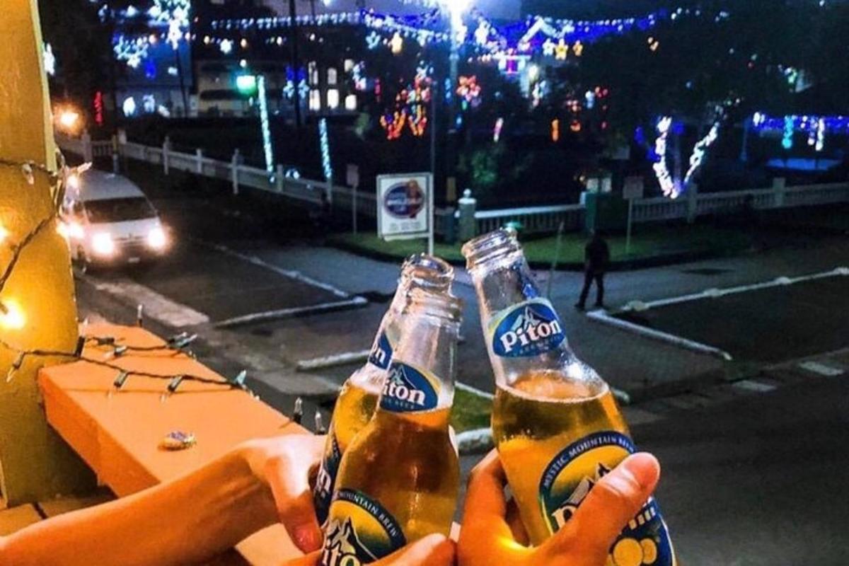 a person holding two bottles of beer in front of a street