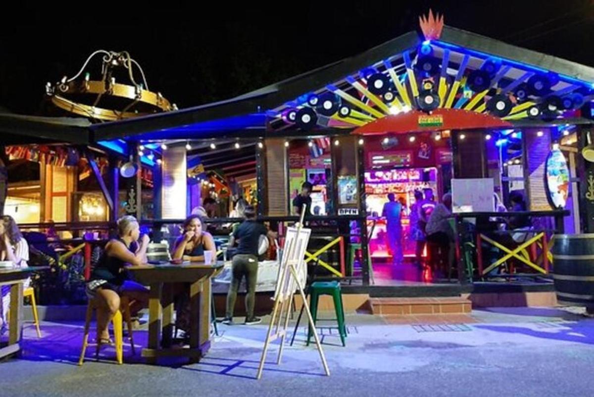 a group of people sitting at a bar at night
