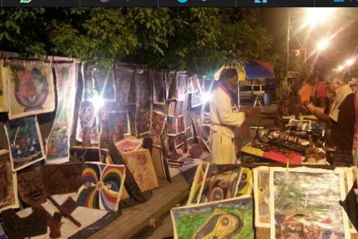 a man standing in front of a market with paintings