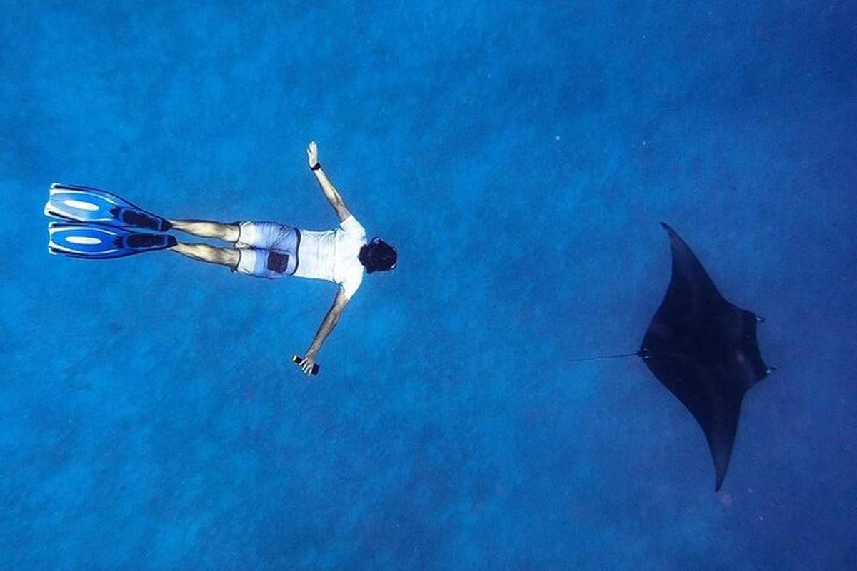 a person floating in the water next to a black umbrella