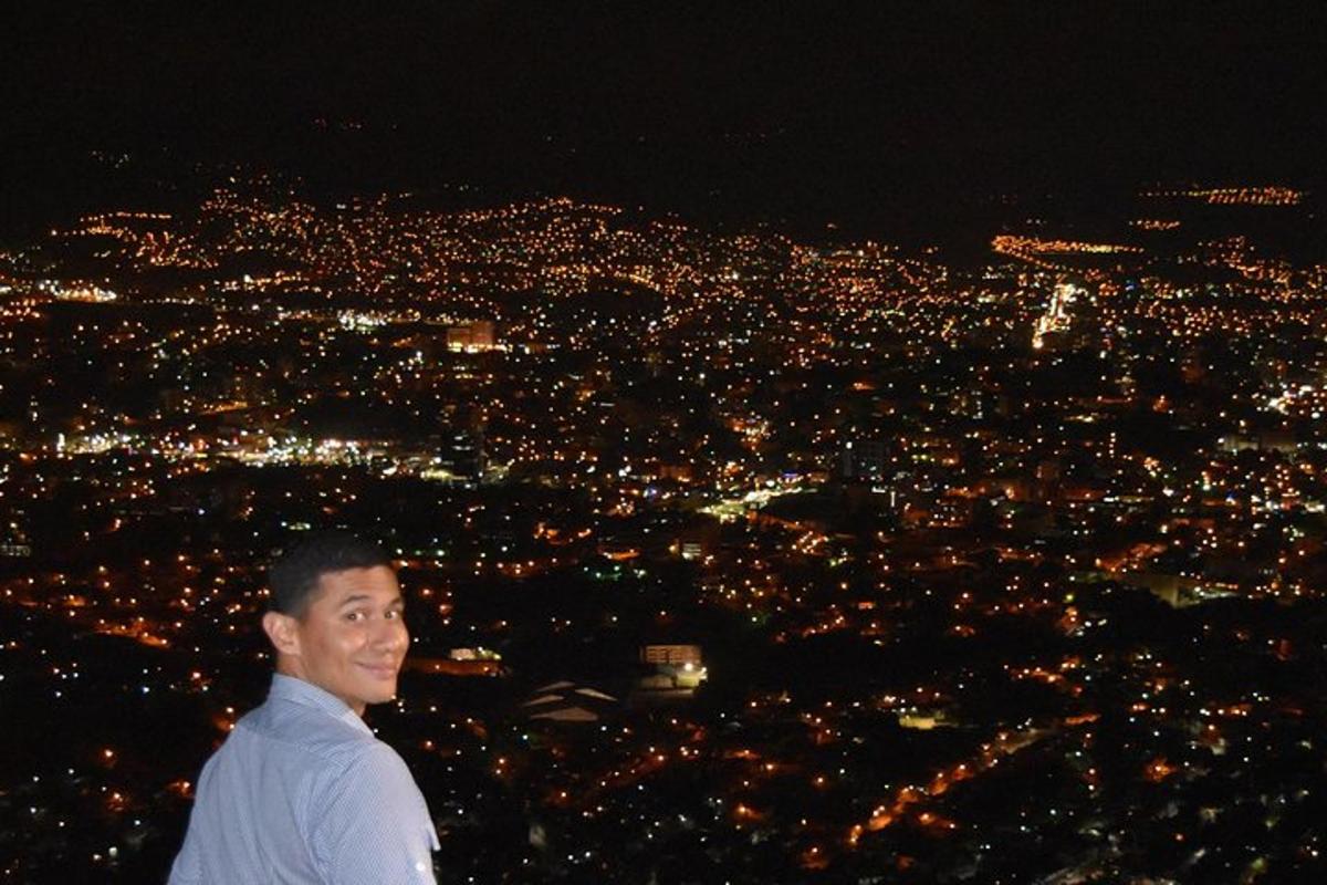 a man standing in front of a city at night