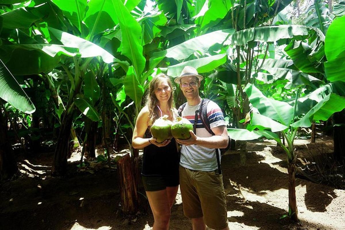 a man and a woman holding green coconuts