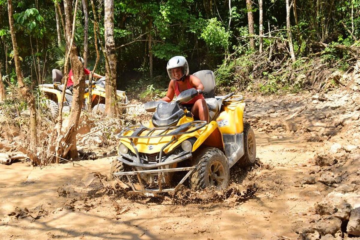 một người đang lái xe bốn bánh trên đường đất
