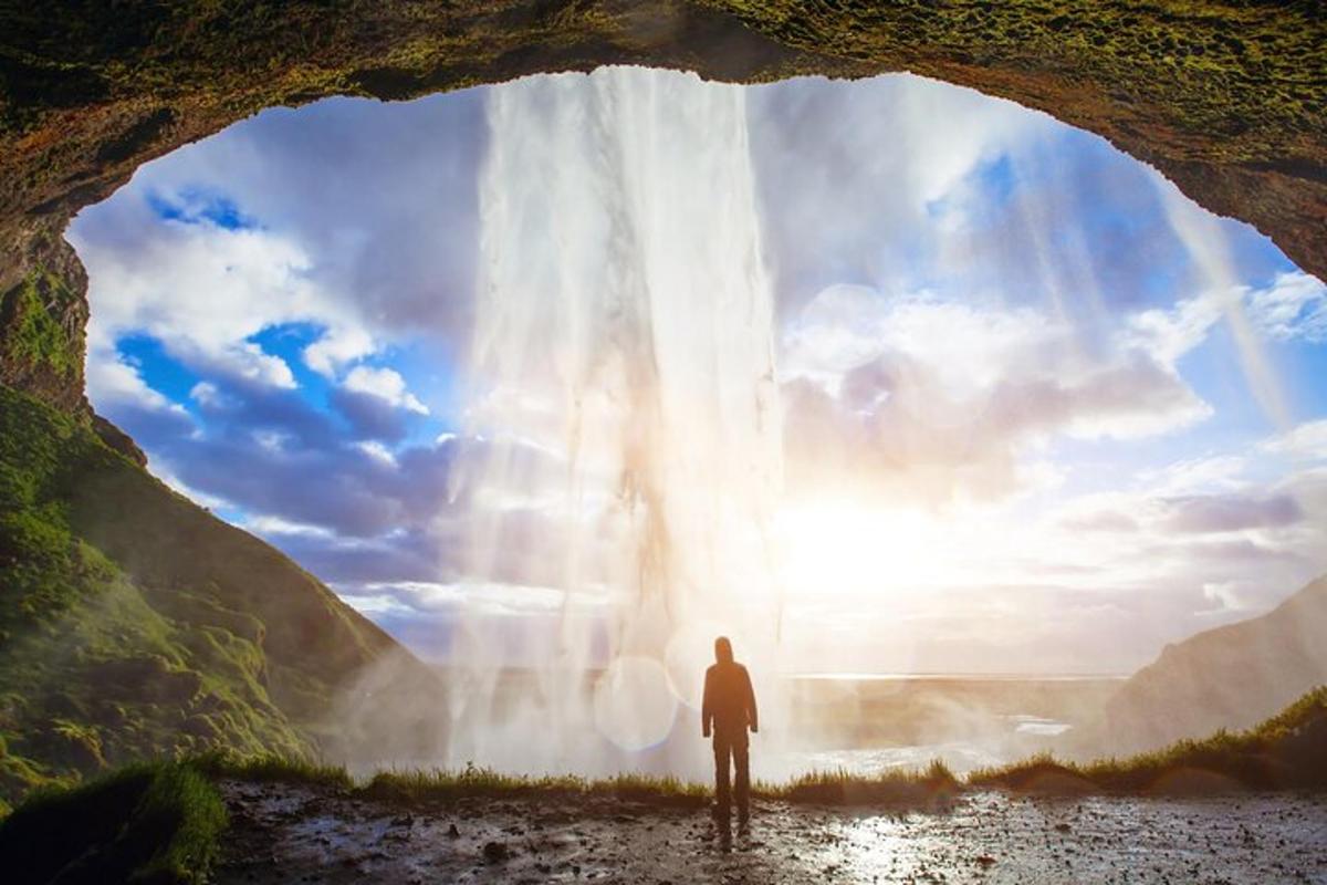 um homem parado em frente a uma cachoeira