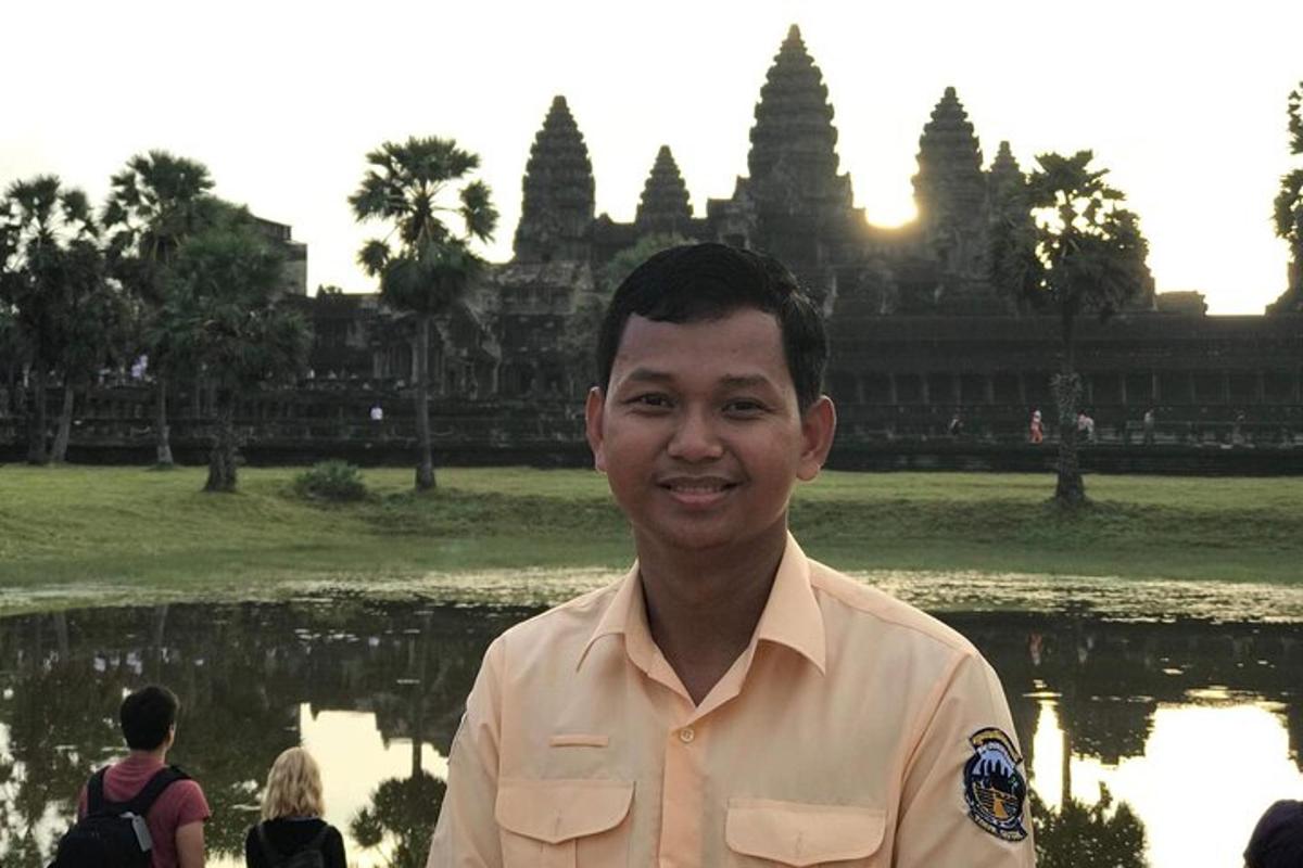 một người đàn ông mặc đồng phục đứng trước một ngôi đền