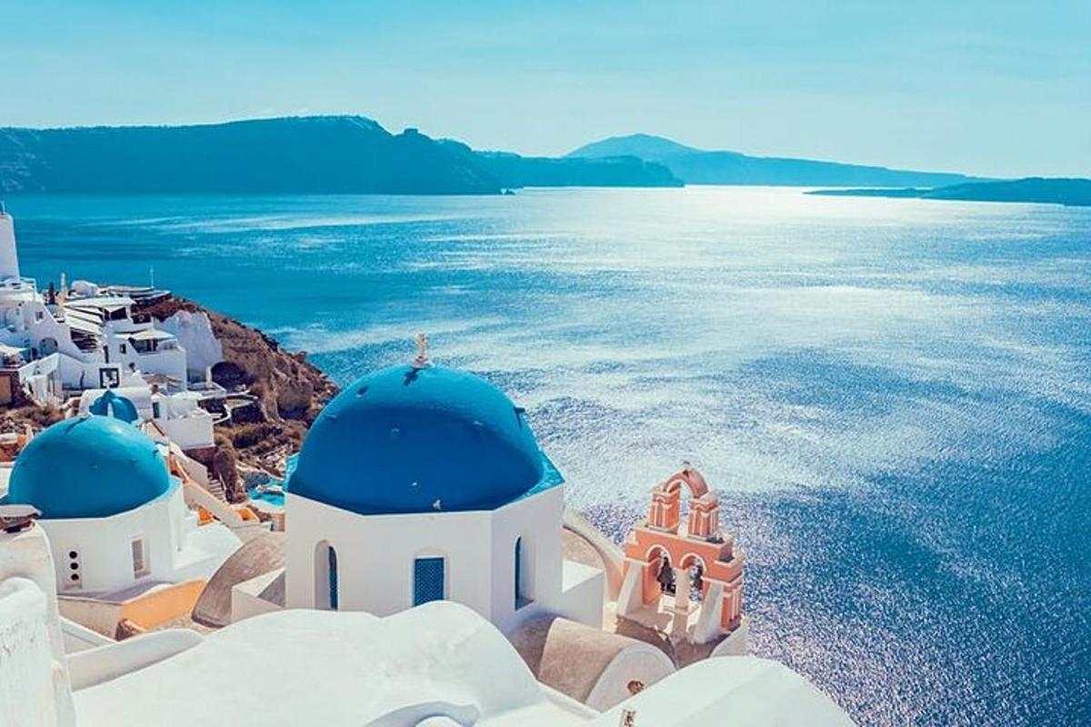 un gruppo di edifici bianchi con cupole blu e l'acqua