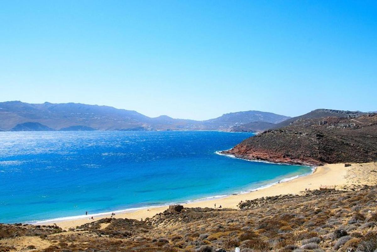una spiaggia con acqua blu e montagne sullo sfondo