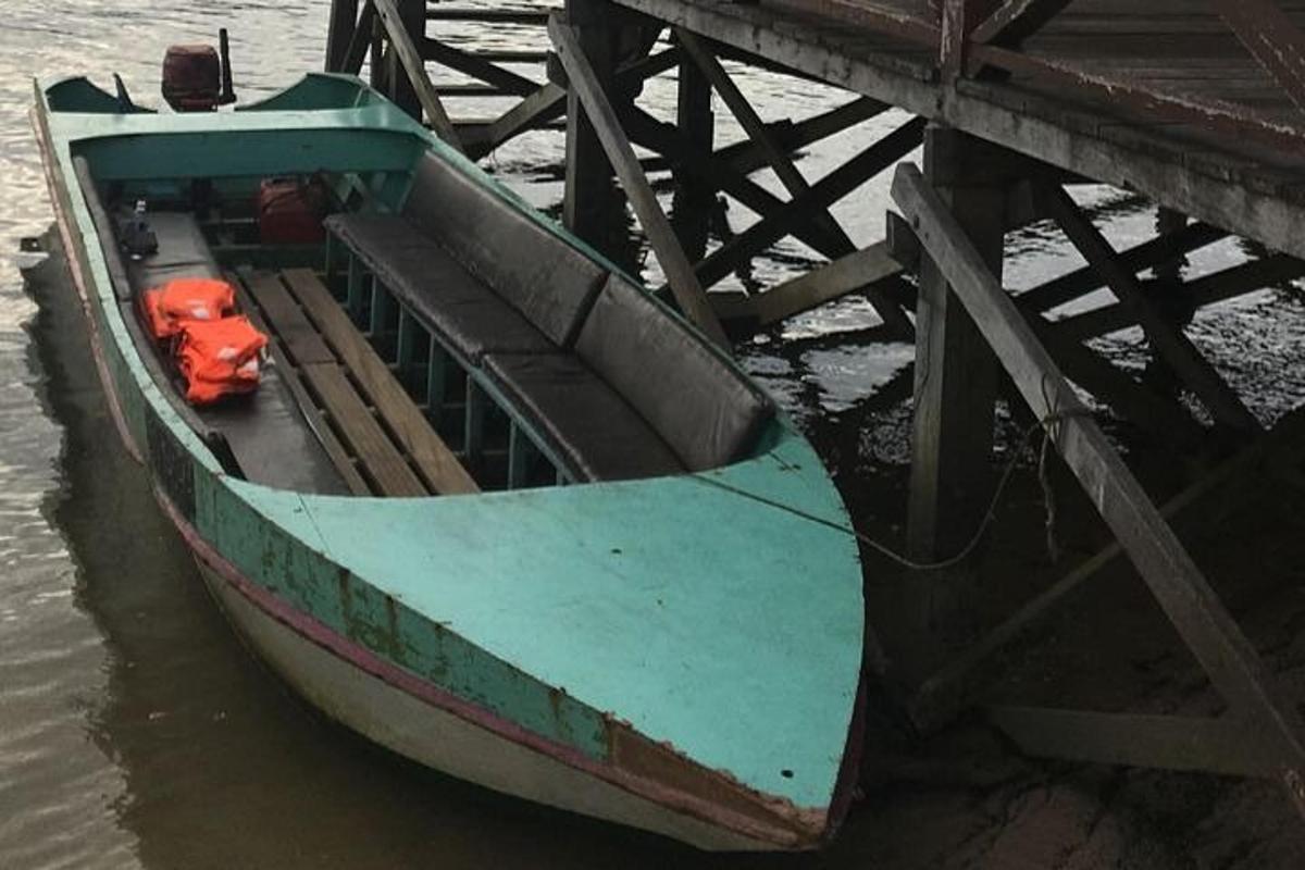 a boat sitting in the water next to a pier
