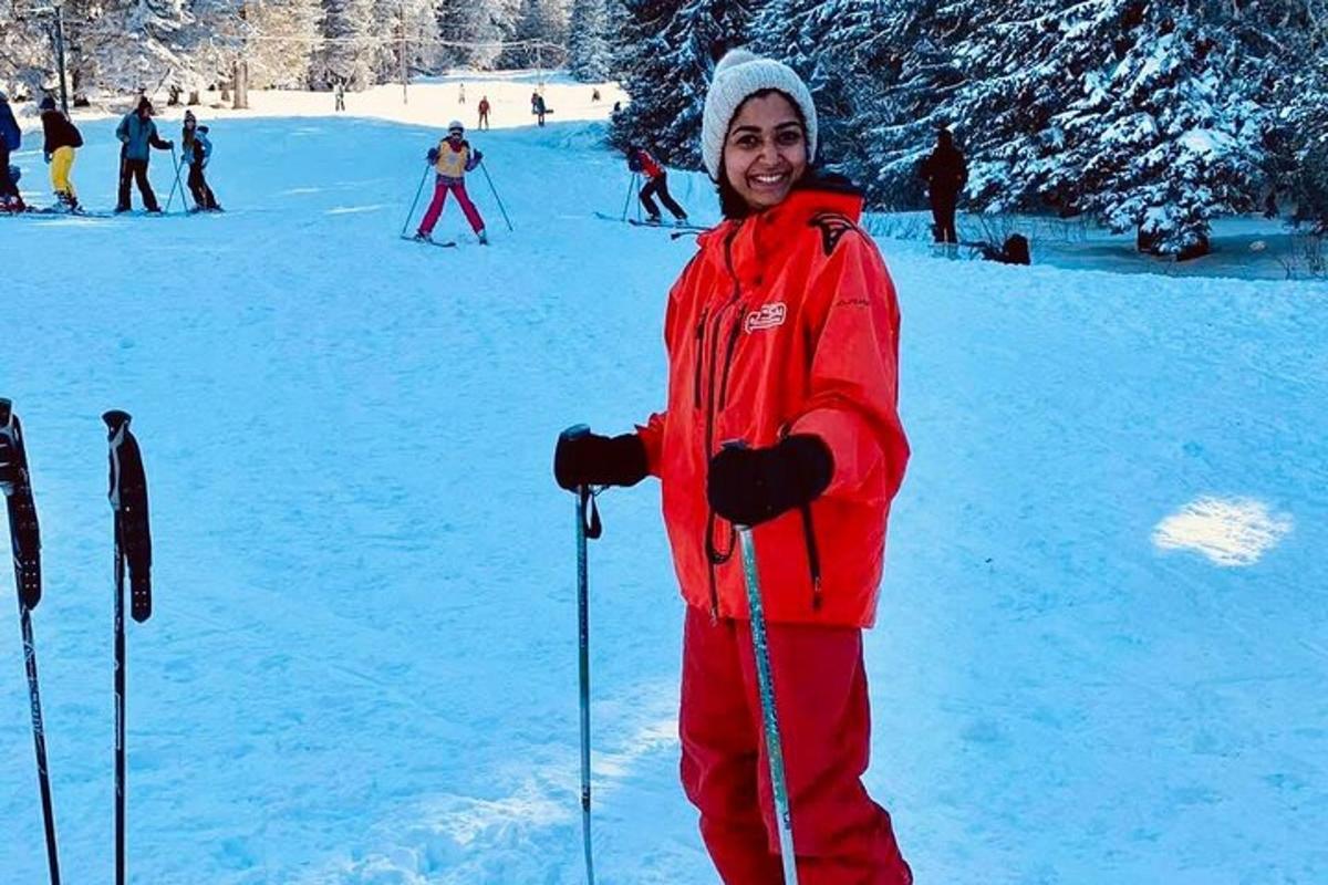 a woman standing in the snow with ski poles