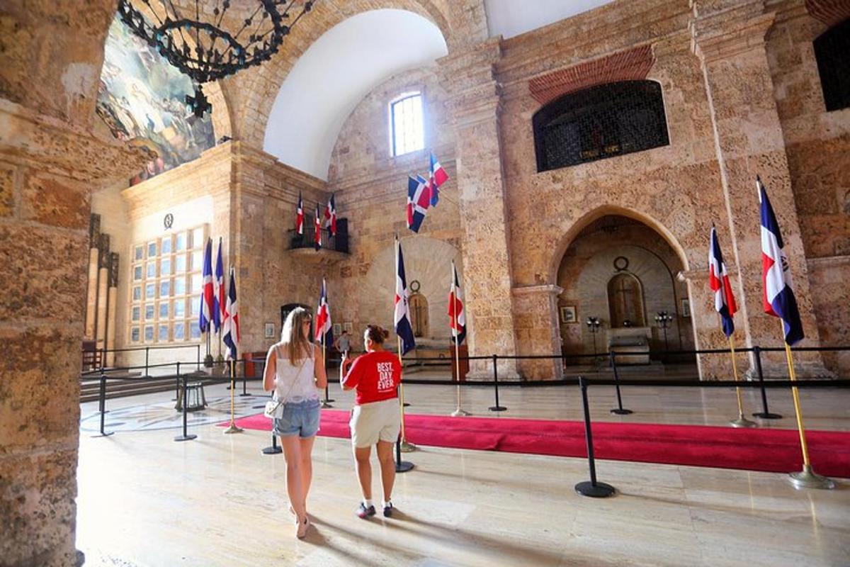 two women walking through a large room with flags