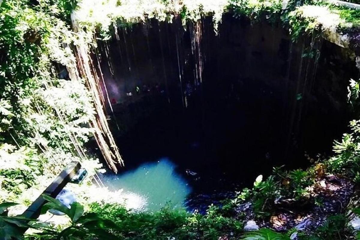 Una persona está parada frente a una cueva.