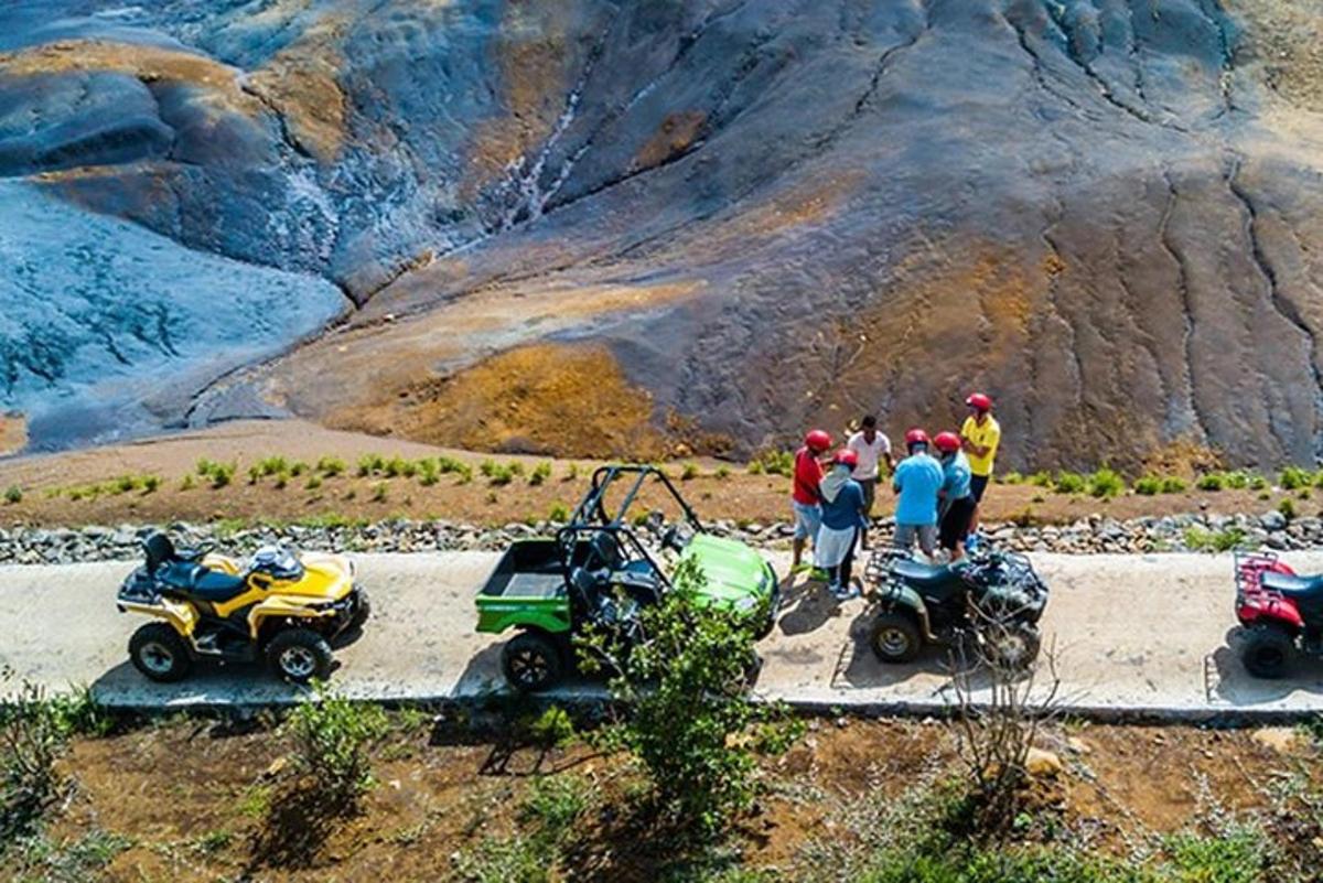 um grupo de pessoas em pé ao lado de seus quadriciclos e motocicletas