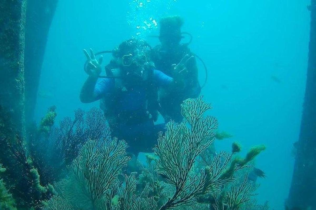 a man taking a picture of a fish in the ocean
