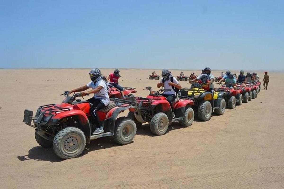 un grup de persones conduint quads al desert