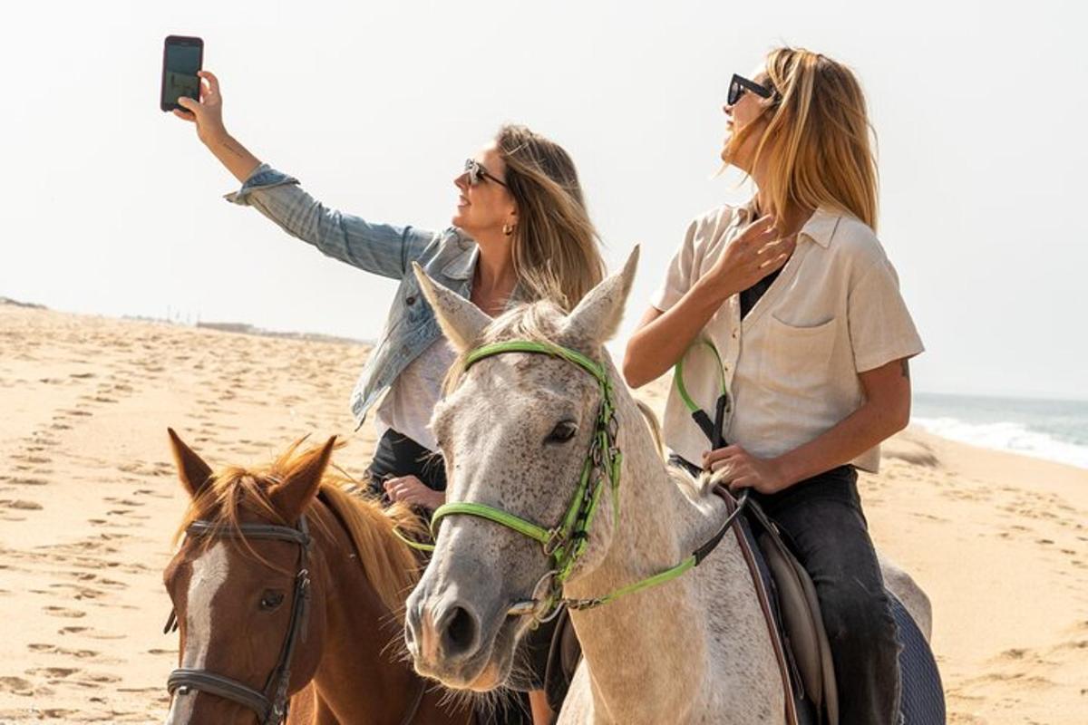 dos mujeres montando a caballo en la playa