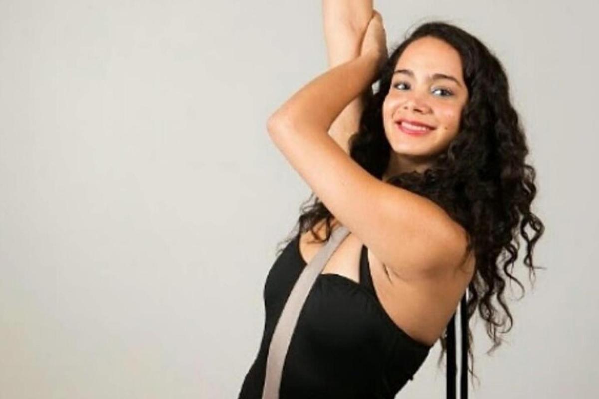 una dona amb un vestit negre amb el braç enlaire