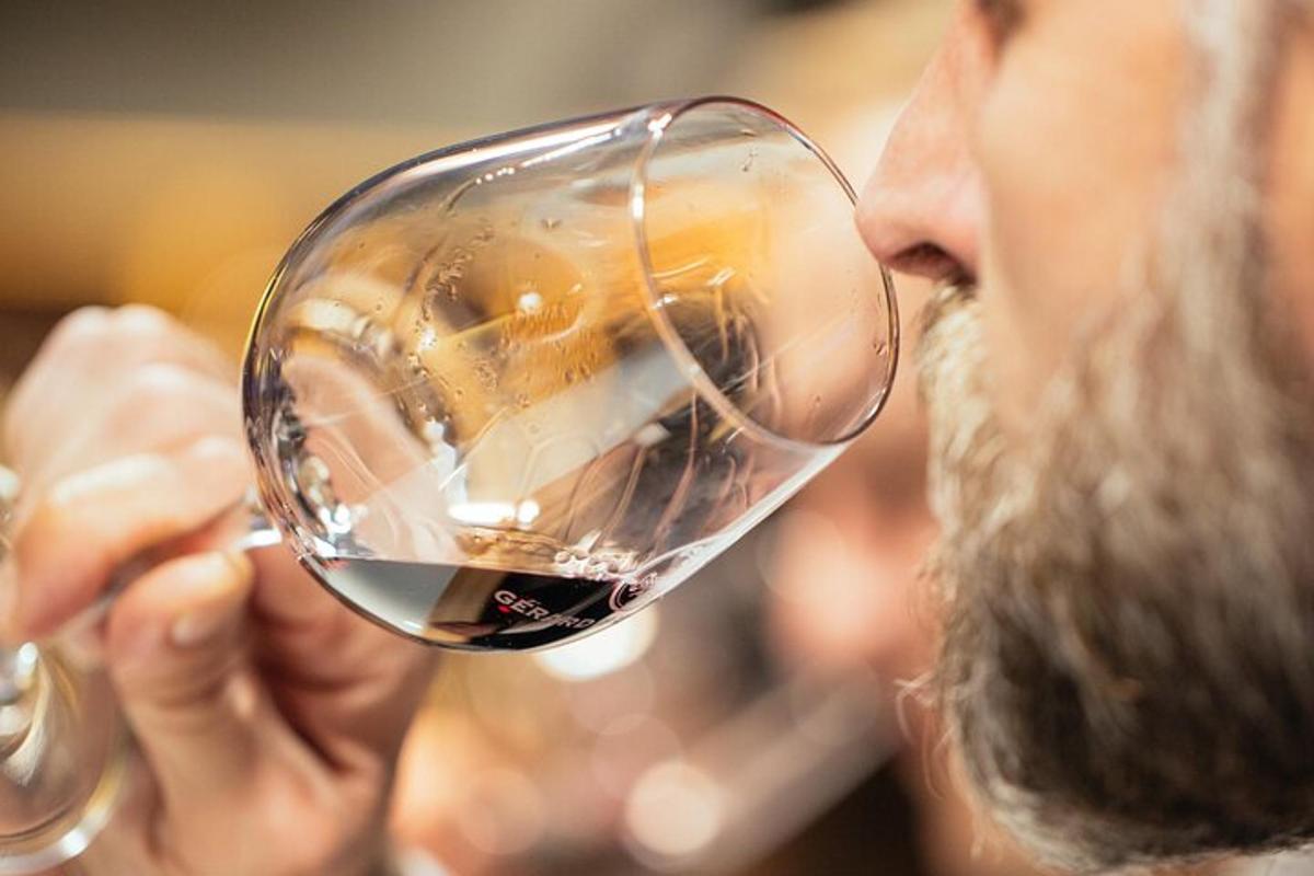 a man drinking from a glass of wine